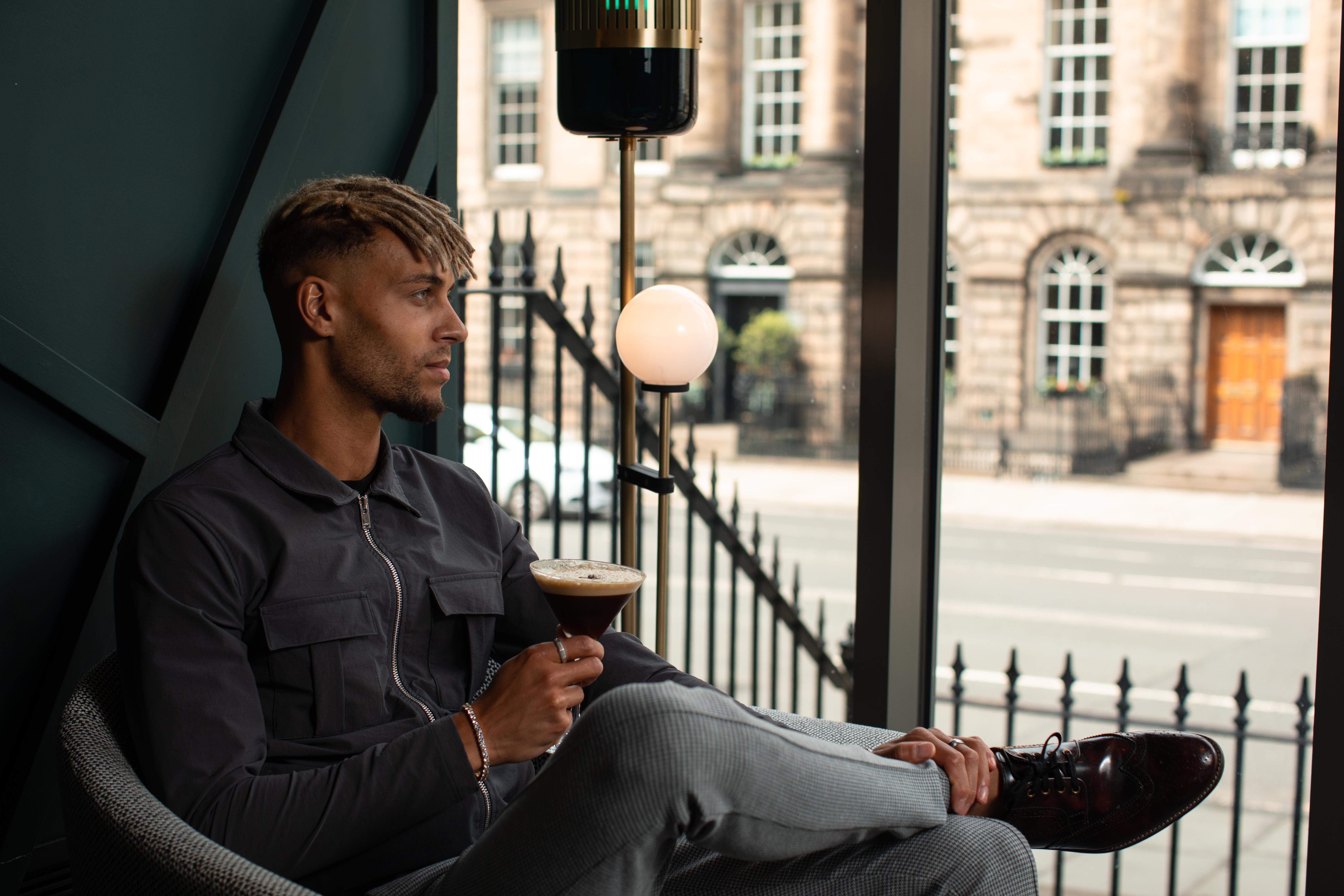 Yotel Edinburgh Exterior photo Photo of a man drinking coffee.